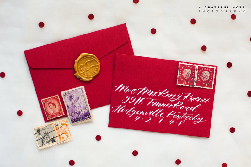Custom White Calligraphy Addressing on Red Envelopes with Gold Wax Seal and Vintage Stamps.